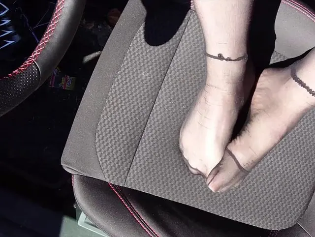 Füße von Nylonjunge in Strumpfhose im Auto
