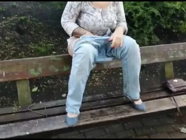 pinkeln im Park auf einer Parkbank