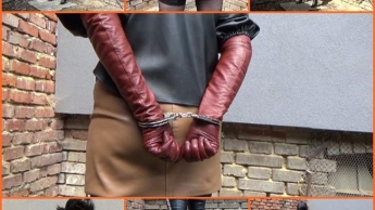 Mit Handschellen gefesselte Frau in Leder und langen Zimthandschuhen