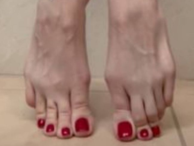 Nackte Füße und lange Zehen mit rotem Nagellack