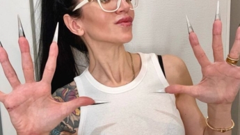 Fingerschnippen und Fingerlutschen mit langen Nägeln, weißer Brille und Gesicht