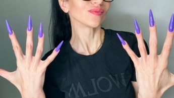 Fingerschnippen und Fingerlutschen mit langen lila Nägeln, Brille und Gesicht
