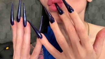 Dunkelblaue lange Nägel, scharfe Stilettos, lange Finger und Beinhaut kratzen