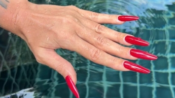 Lange ROTE Nägel und lange Finger im Schwimmbad