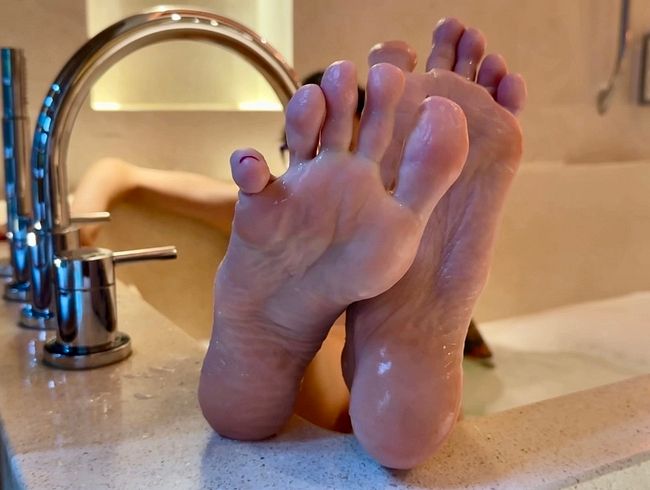 Meine rosa Sohlen in einer Wanne, nackte Füße mit langen Zehen, nasse, faltige Sohlen