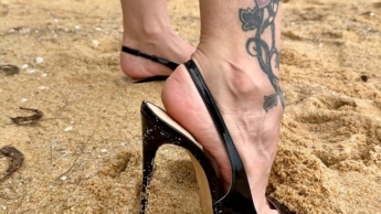 Schwarze klassische Stiletto High Heels ohne Fersenkappe, 12 cm Absatz an mir und am Strand, im Sand