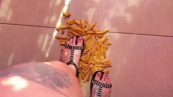 Pommes frites in flachen Sandalen zerdrücken