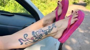Rosa Flip-Flops an meinen hübschen Füßen mit langen Zehen im Freien, auf der Straße, im Gras, im Auto, rot lackierte Zehennägel