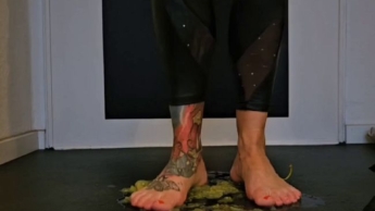 In High Heels und mit nackten Füßen Weintrauben klein treten