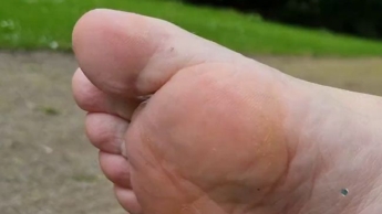 Fetisch im Park: Turnschuhe, weiße Socken, nackte Füße