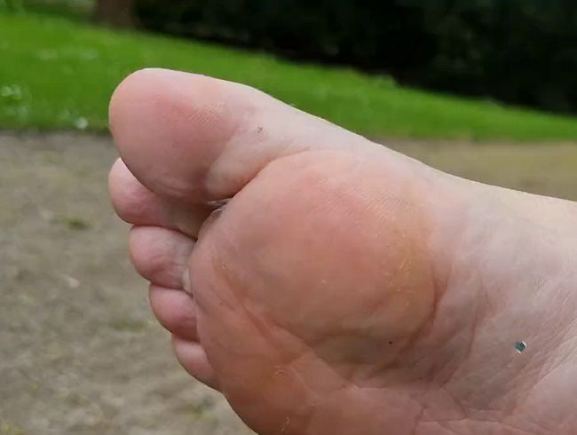 Fetisch im Park: Turnschuhe, weiße Socken, nackte Füße