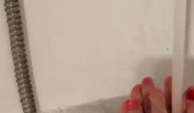 Füße im Schaum im Wasserstrahl plätschern