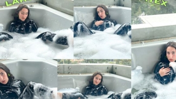 Ich badete in einem Whirlpool, bekleidet mit meinem schwarzen Latexanzug, während meine Nachbarn in Sichtweite waren.
