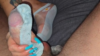 Stiefmutter mit langen Nägeln gibt einen Handjob mit Socke